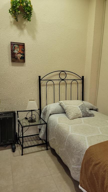 een slaapkamer met een bed en een tafel met een lamp bij ALOJAMIENTO RURAL LOS MOLINOS in Gátova