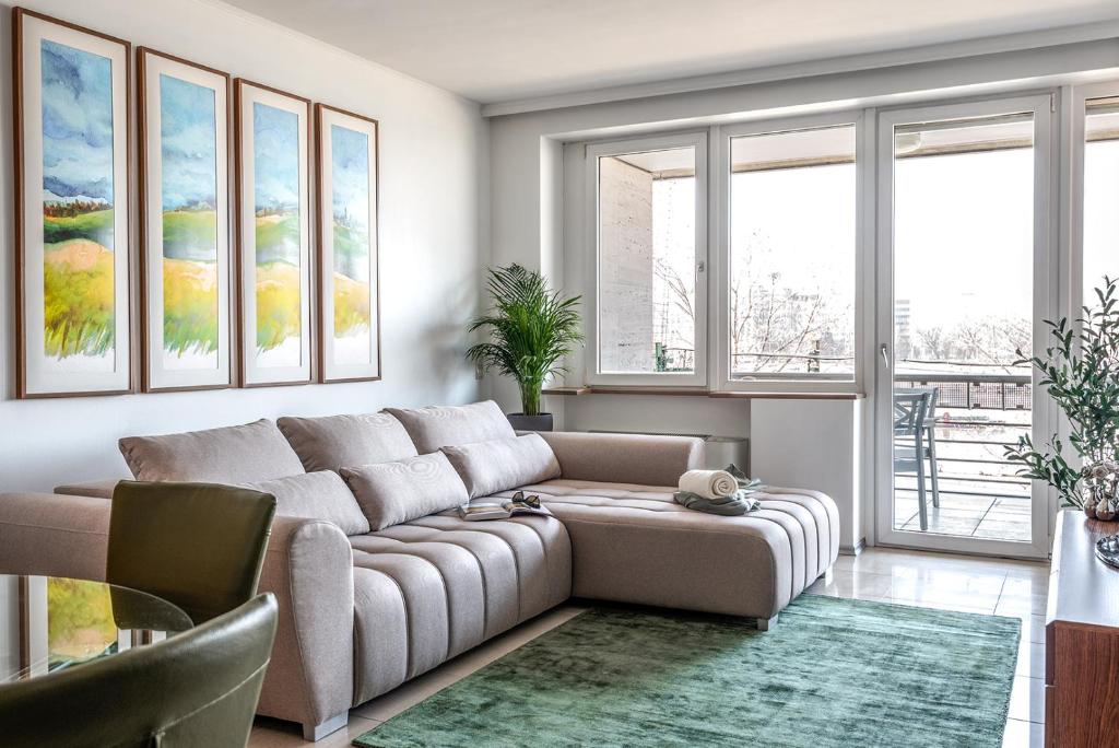 uma sala de estar com um sofá e algumas janelas em Dunapest Apartman em Budapeste