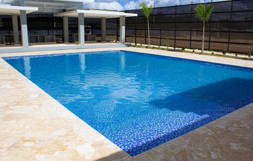 a large blue swimming pool in front of a building at Caribbean Apartment in La Romana