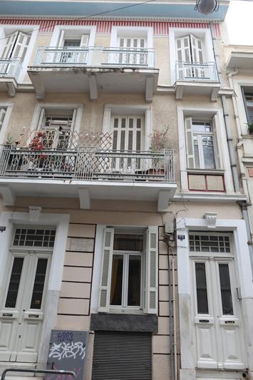 - un grand bâtiment blanc avec des fenêtres et un balcon dans l'établissement Όμορφο διαμέρισμα σε διατηρητέο κτίσμα στην Αθήνα, à Athènes