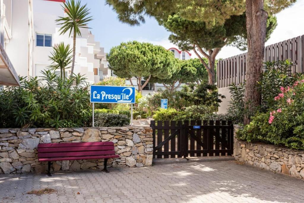 ein Straßenschild neben einer roten Parkbank in der Unterkunft Studio Gruissan La Presqu'île 2 in Gruissan