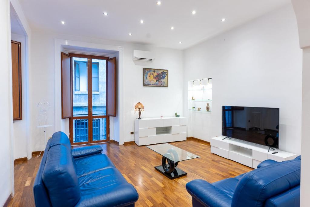 a living room with a blue couch and a tv at Dimora del Fico - Appartamento elegante e spazioso in Naples