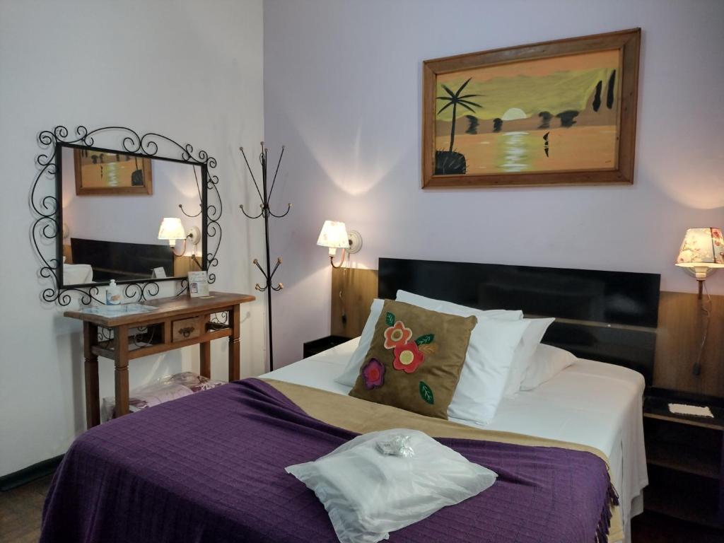 una habitación de hotel con una cama y un espejo en Pousada Vila Inconfidentes - Centro Historico, en Tiradentes