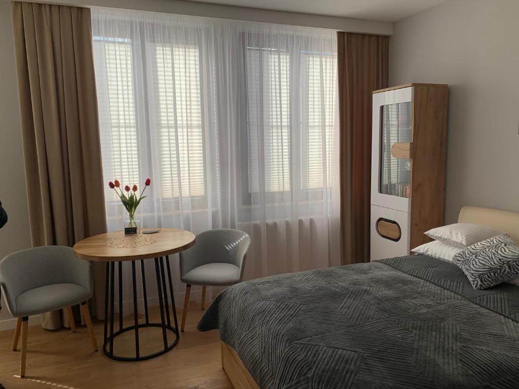 a bedroom with a bed and a table and chairs at Apartament Perłowy in Zamość