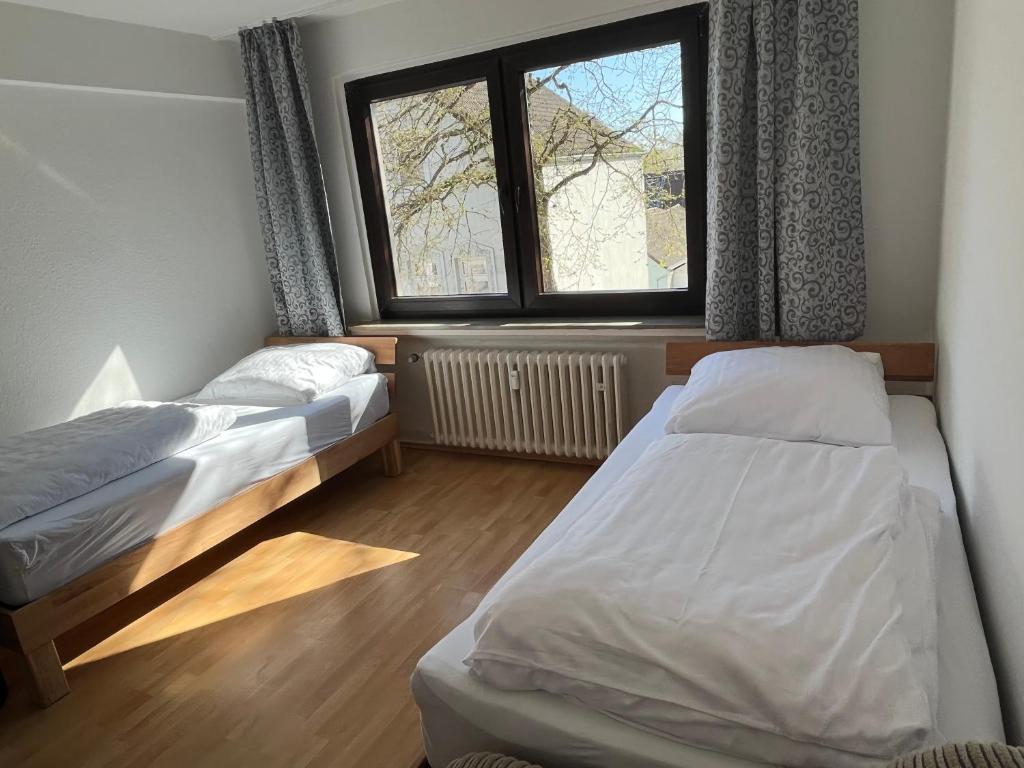 1 dormitorio con 2 camas y ventana en Zimmer für Monteure, Handwerker oder Reisende, en Essen