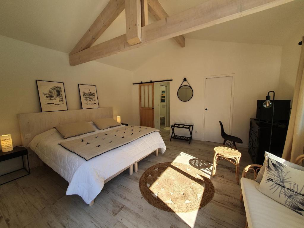 ein Schlafzimmer mit einem großen Bett und einem Sofa in der Unterkunft B&B Les Villas de Gascogne in Lanton