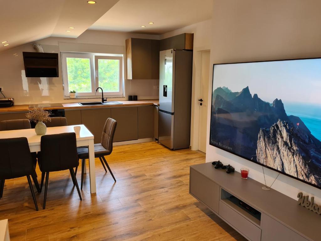a kitchen and living room with a large screen television at Nova Apartments in Poljica