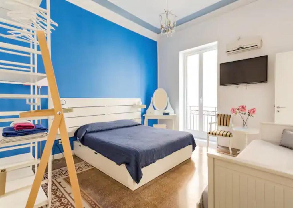 - une chambre avec des murs bleus et un lit avec une échelle dans l'établissement Charmie flat, à Palerme