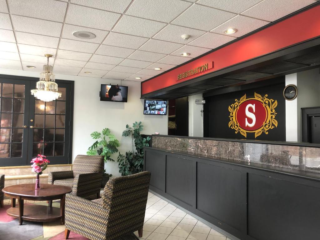 een restaurant met een bar met een bord erop bij The Schenectady Inn & Suites in Schenectady
