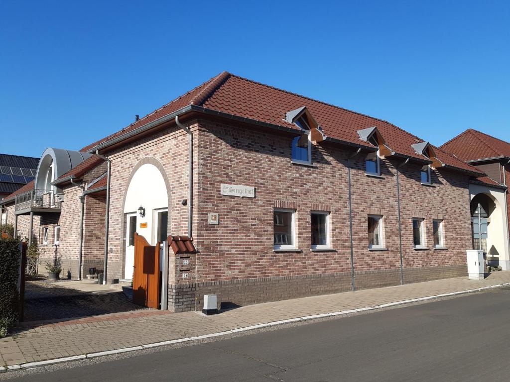 un edificio de ladrillo al lado de una calle en Aan het Singelhof - Mirabelle -- 4 sterren -- met sunshower en tuin, en Sint-Truiden