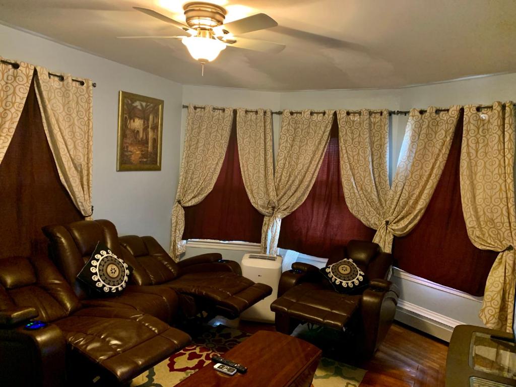 a living room with leather furniture and curtains at The dream stylish apartment near Providence in Pawtucket