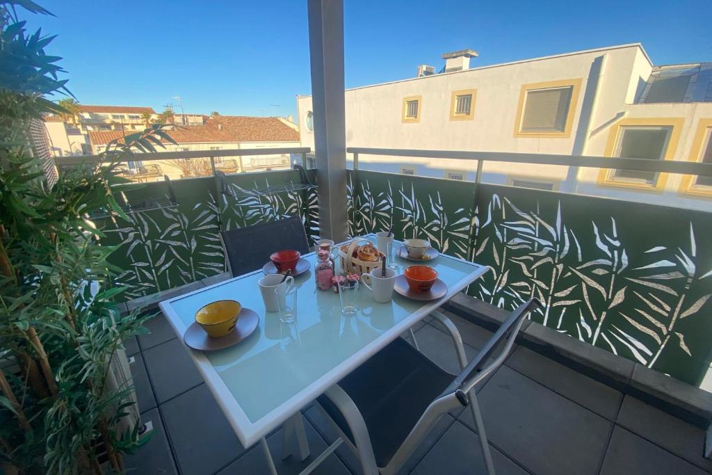una mesa blanca en un balcón con comida. en La Roseliere, en Le Grau-du-Roi