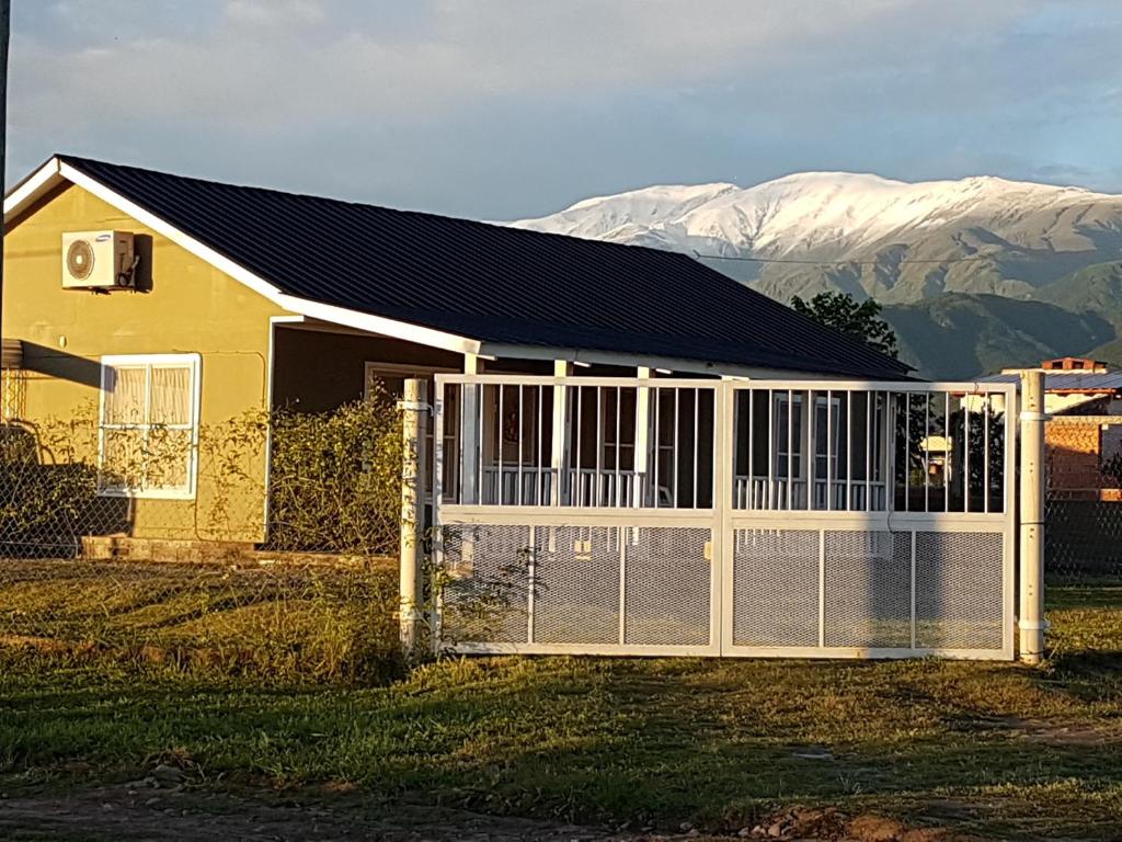 a house with a fence and mountains in the background at VICTORIA ANDINA I in Salta