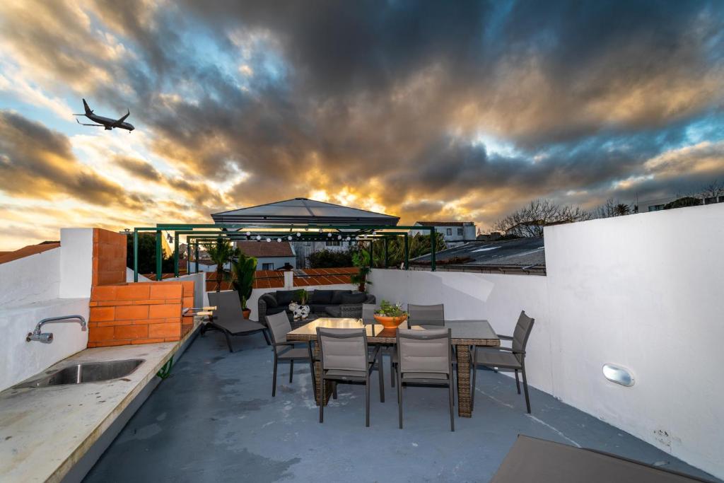 an airplane flying in the sky over a patio at Francisco Terrace in Ponta Delgada