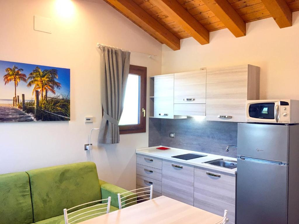 eine Küche mit einem Kühlschrank, einem Sofa und einem Tisch in der Unterkunft Ca' Rosin Meolo - Camera tra relax e privacy in Meolo