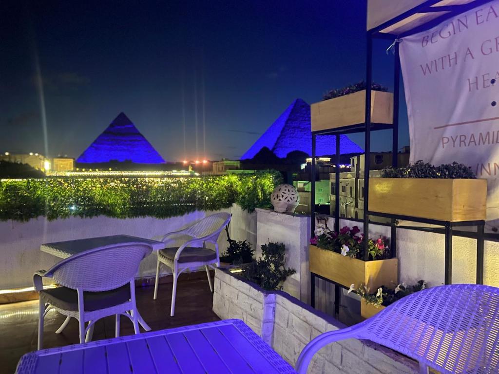 a patio with purple tables and chairs at night at Pyramids Top Inn in Cairo