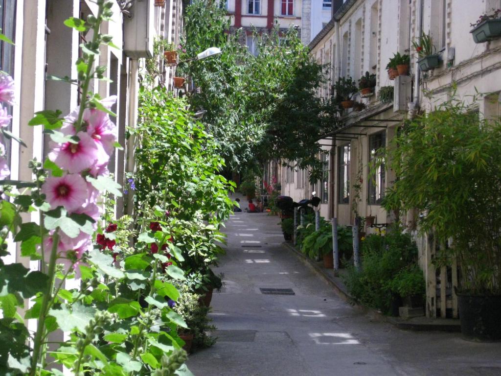 um beco vazio com flores e edifícios em Cité Pilleux - Charming Studio in a flowery pedestrian lane em Paris