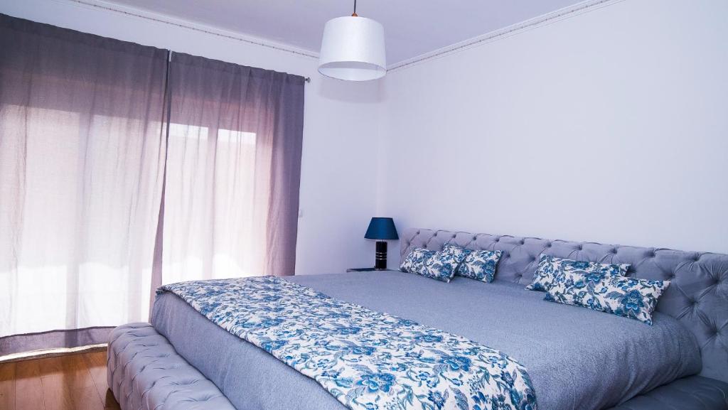 a bedroom with a large bed with a blue blanket at Casa Miguelito in Aveiro