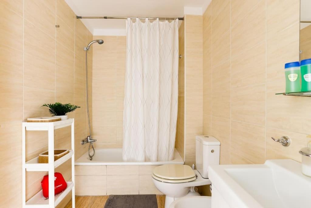 a bathroom with a toilet and a tub and a sink at Appartamento Mochiri - San Isidro in San Isidro