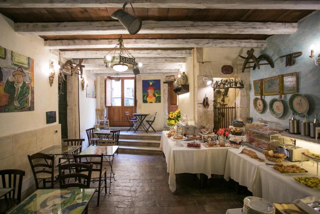 restauracja ze stołami i krzesłami, na których znajduje się jedzenie w obiekcie Hotel Henry's House w Syrakuzach