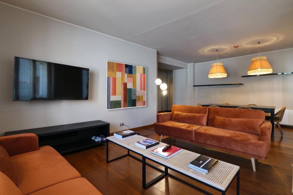 salon z 2 kanapami i telewizorem w obiekcie Castello Luxury Apartment - in the heart of Milan w Mediolanie
