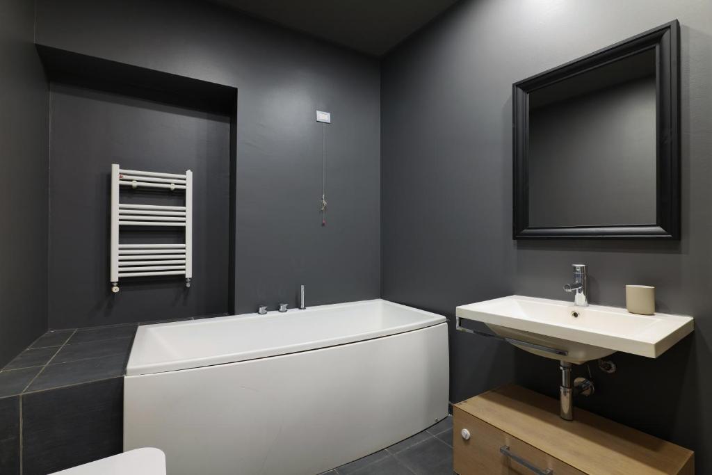 łazienka z białą wanną i umywalką w obiekcie Castello Luxury Apartment - in the heart of Milan w Mediolanie