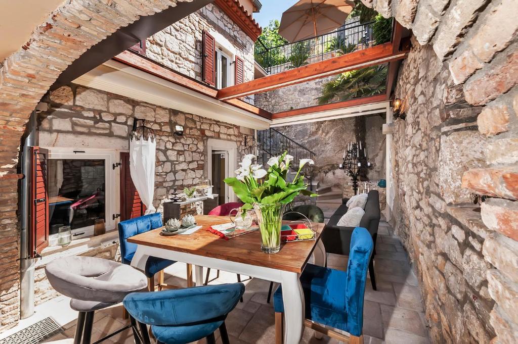 een eetkamer met een tafel en blauwe stoelen bij Luxury Villa Orh Rovinj in Rovinj