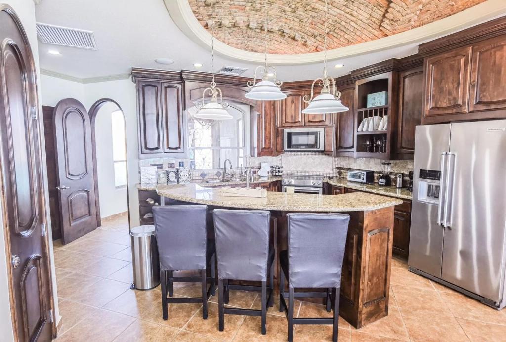 a kitchen with a large center island with bar stools at Esmeralda by TO in Puerto Peñasco