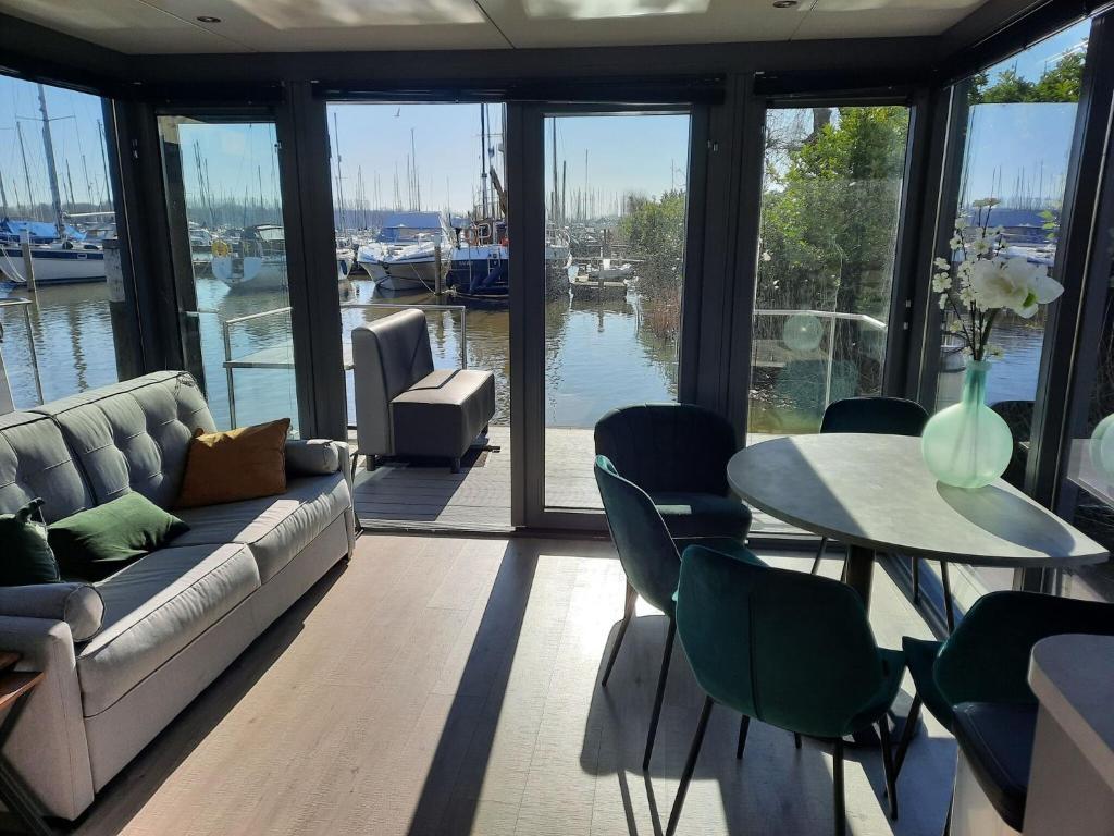 uma sala de estar com um sofá e uma mesa com cadeiras em Waterfront houseboat in Monnickendam near the centre em Monnickendam