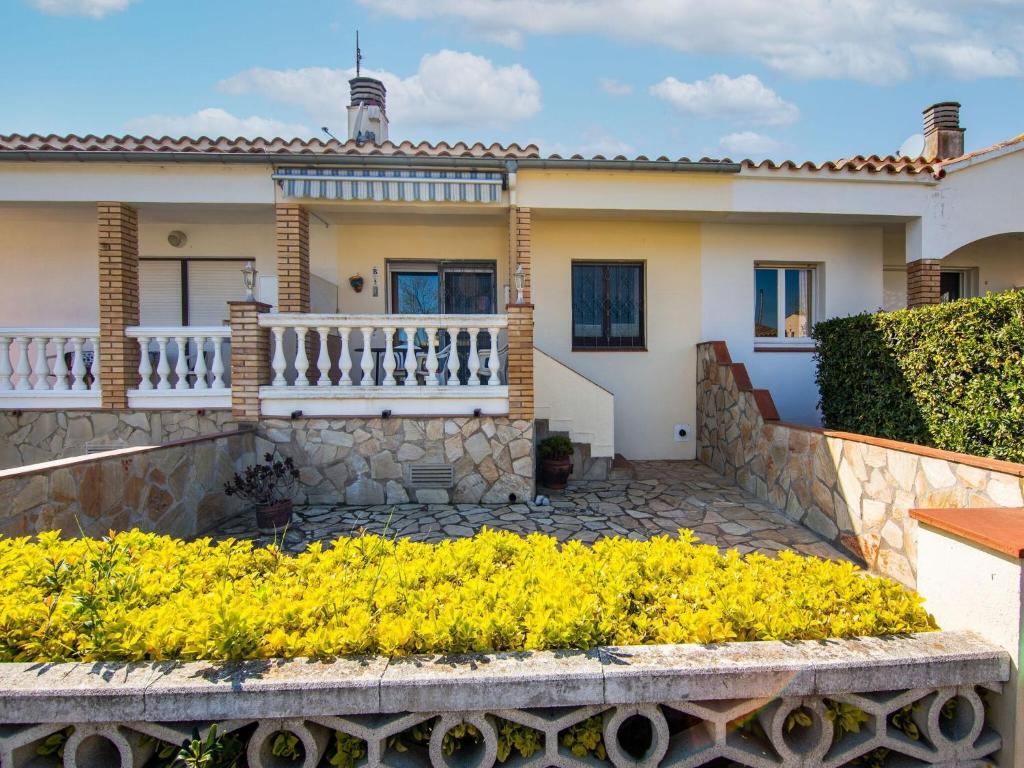 una casa con balcone e fiori gialli di Belvilla by OYO Sant Pere Playa a Sant Pere Pescador