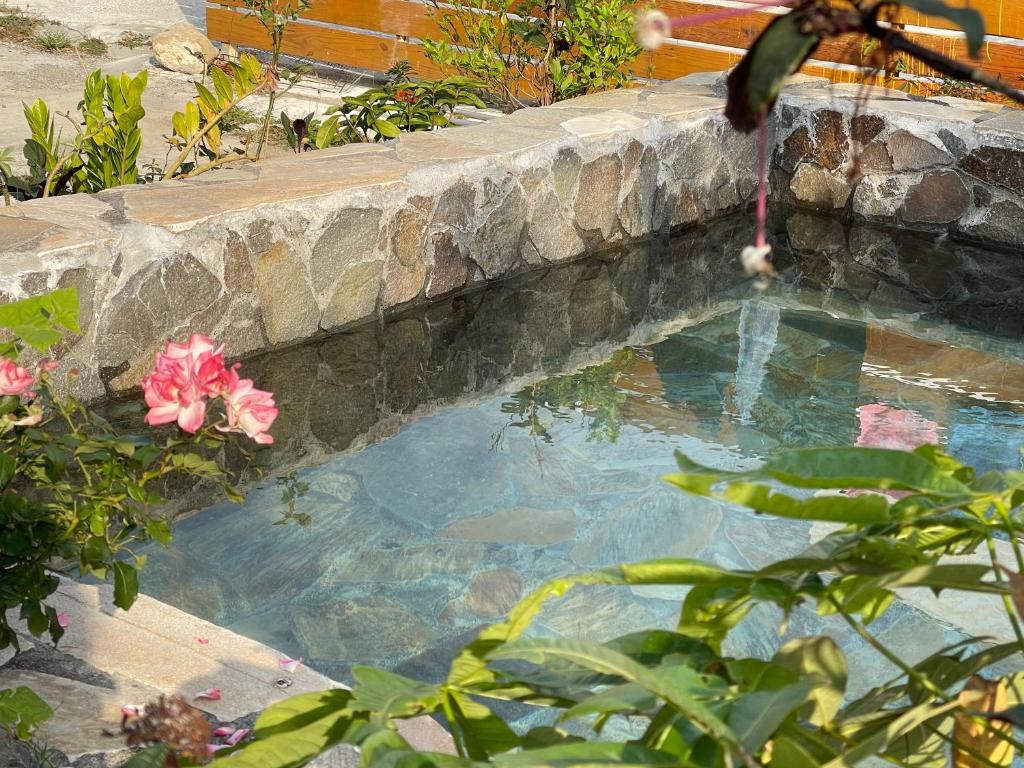 a pool of water with a hose in a stone wall at 寧靜的家14人Villa獨立設施包棟戲水池烤肉區麻將廚房私人停車場 in Hengchun South Gate