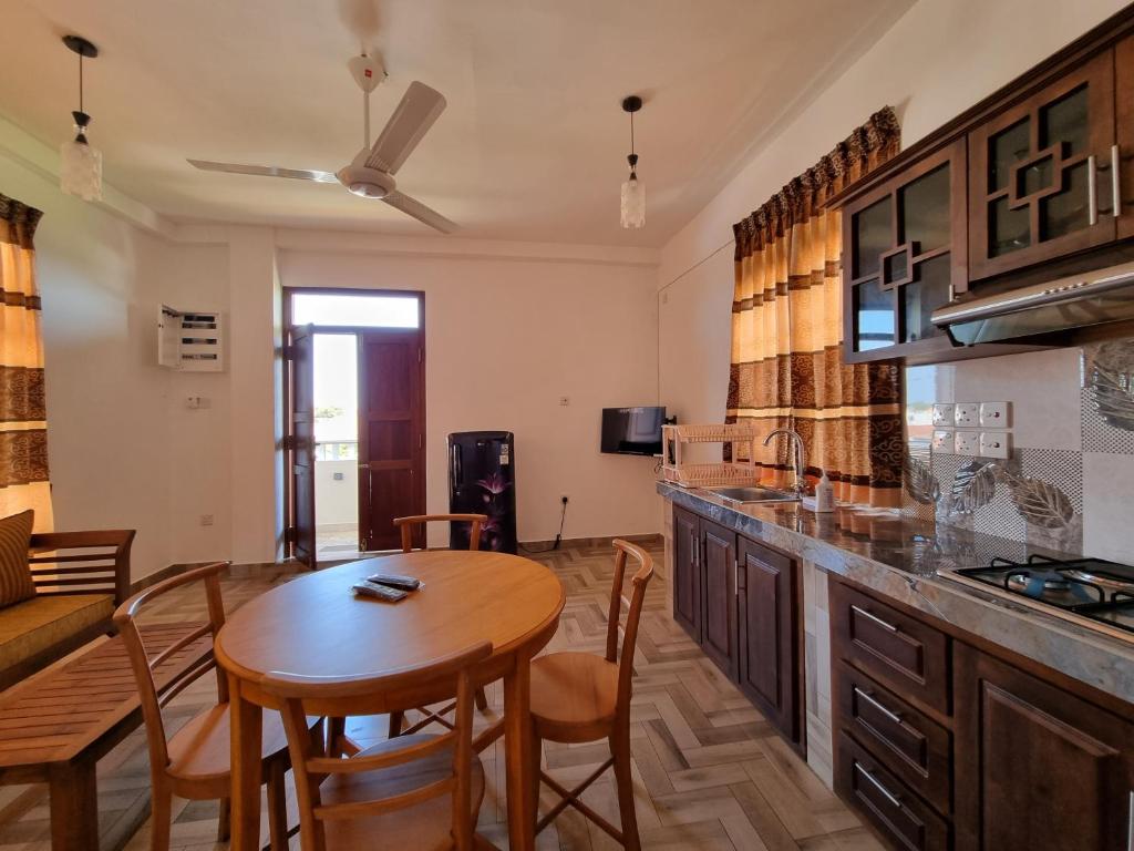 a kitchen and dining room with a table and chairs at Grand Station Residence (Rose) in Seeduwa