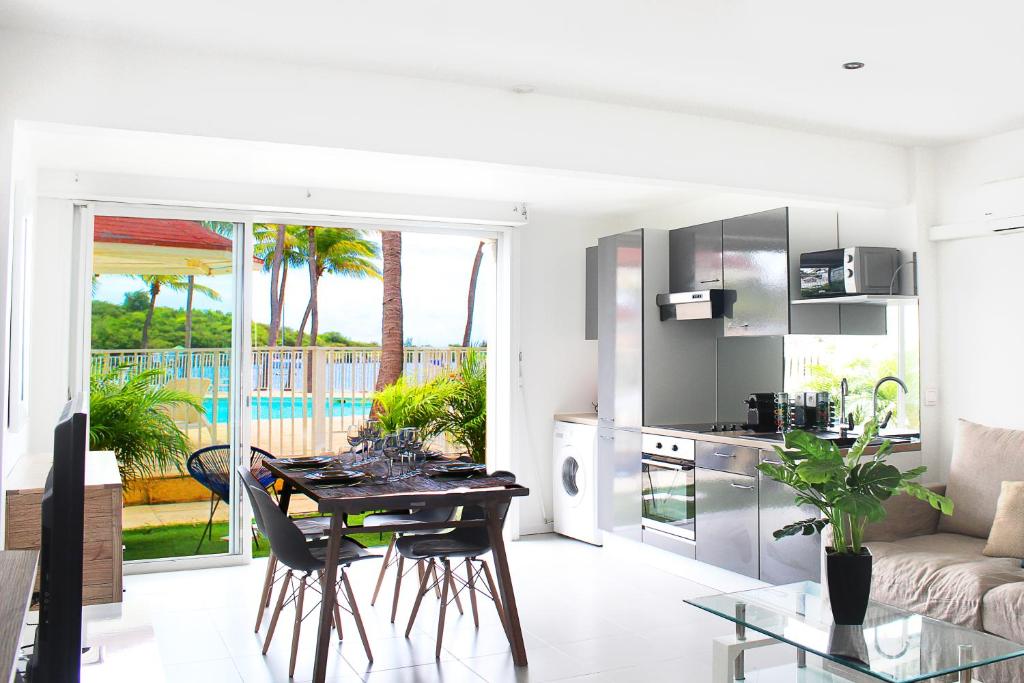 a living room with a table and a kitchen with a view at Blue Vista - 1 bedroom condo in Nettle Bay in Marigot