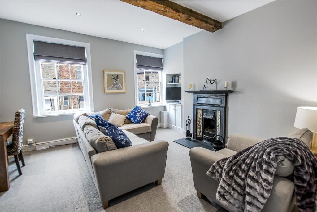 a living room with two couches and a fireplace at Comfy Dales holiday base on Market Place of historic market town in Richmond