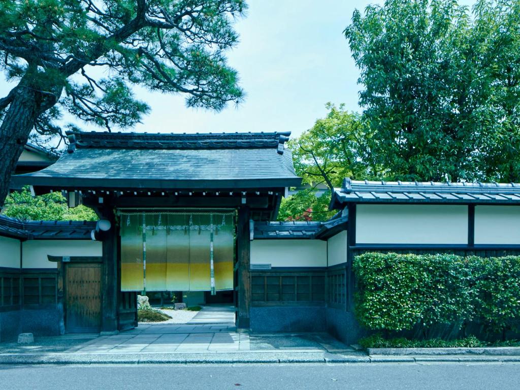 a building with a gate in the middle of a street at Ryokan Genhouin in Kyoto