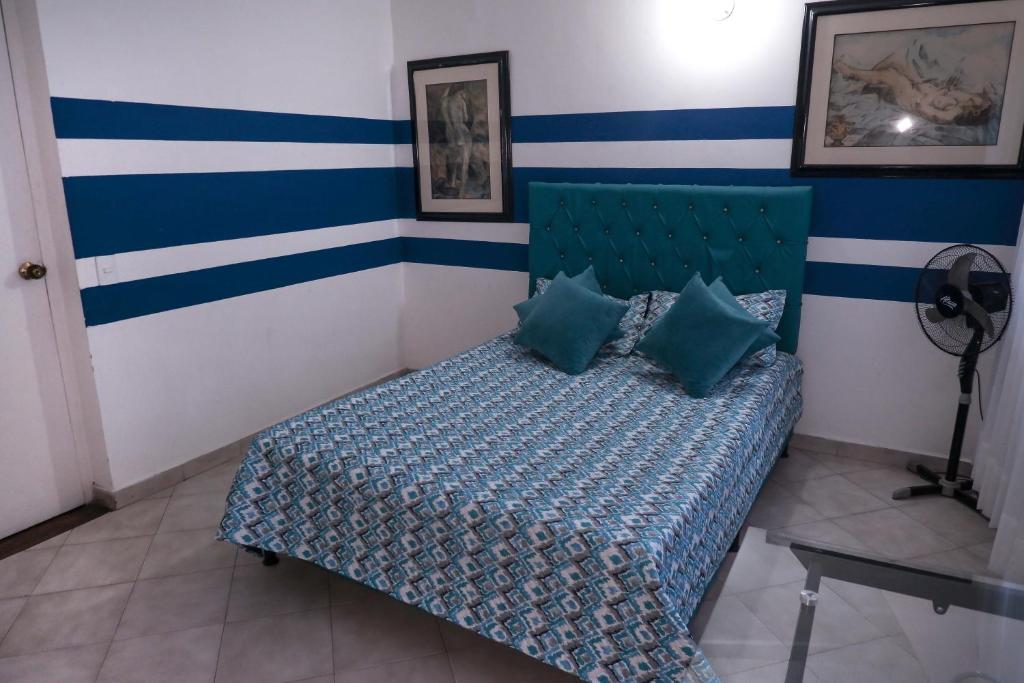 a bedroom with a bed with blue and white stripes at Casa La Palma Habitación Cielo in Medellín