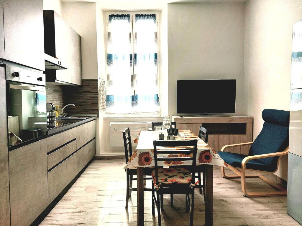 cocina con mesa y sillas en una habitación en L'arco blu, en Albisola Superiore