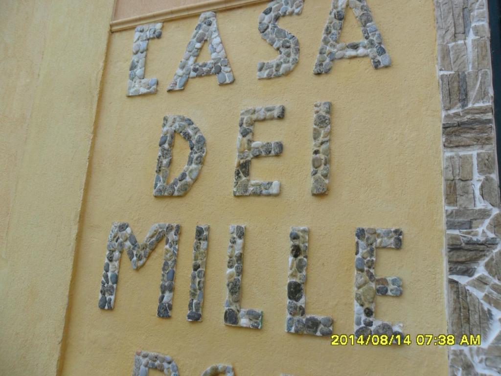 a sign on the side of a building with rocks at B&B Casa Dei Mille in Pizzo