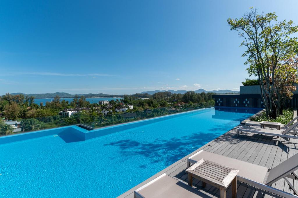 a large swimming pool with a view of the water at Aristo 2 Phuket in Phuket Town