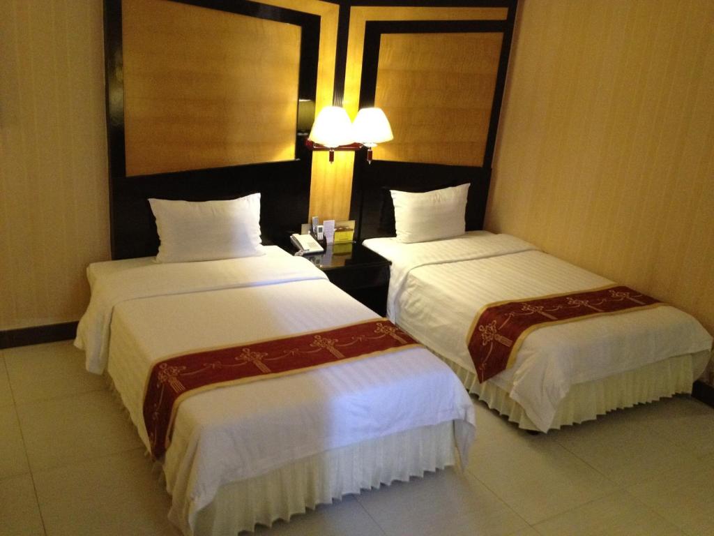 Postel nebo postele na pokoji v ubytování Guang Dong Hotel