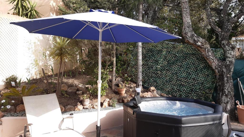 a blue umbrella sitting next to a hot tub at Appartement Maison Croisette in Sainte-Maxime