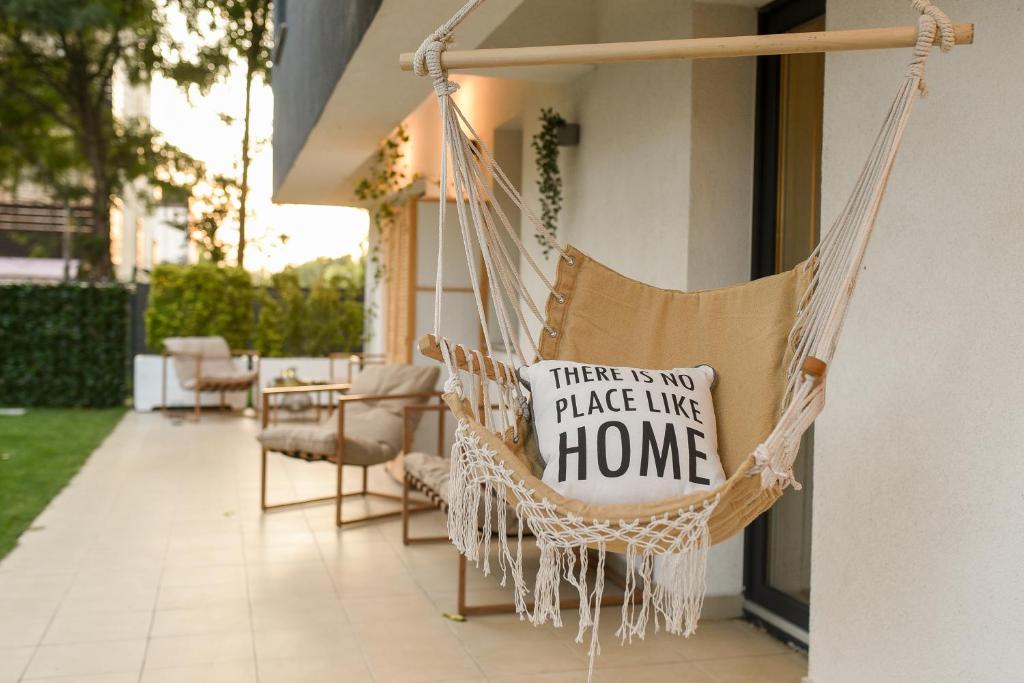 a hammock with a sign that says there is no place like home at VACATION FEEL - 2BR Apartment with Terrace & Private Parking in Baneasa in Bucharest