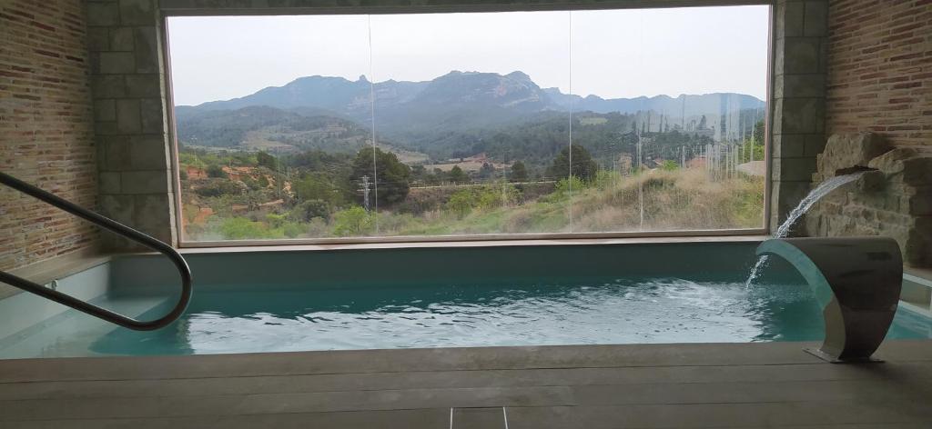 a bath tub with a large window with a view of a mountain at Hotel & Spa Can Josep in Bot