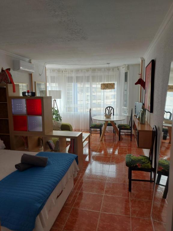 トレモリノスにあるAcogedor estudio en el centro torremolinosのベッドルーム1室(ベッド1台付)、リビングルームが備わります。