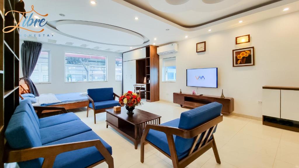 a living room with blue chairs and a couch at Libré Homestay Đào Tấn in Hanoi