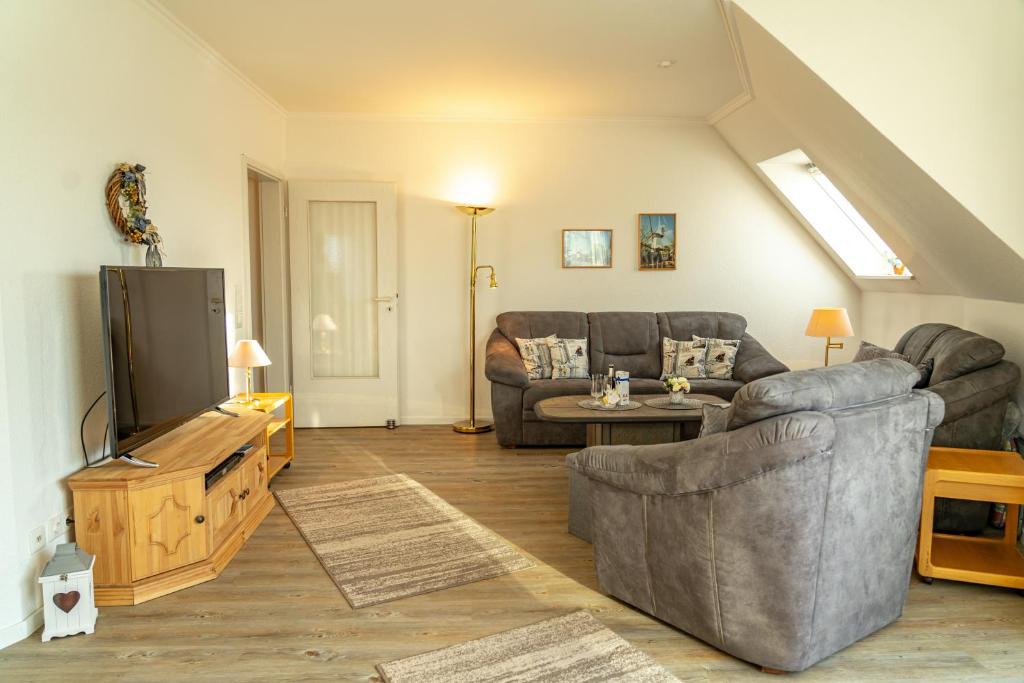sala de estar con sofá y TV en Haus Nordstrand Vereinsallee 21, en Büsum