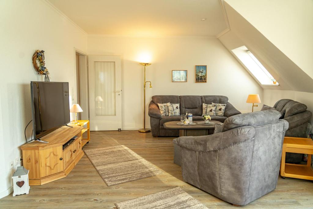 Una sala de estar con un sofá y un televisor. en Haus Nordstrand Vereinsalle 21WHG 2 6, en Büsum