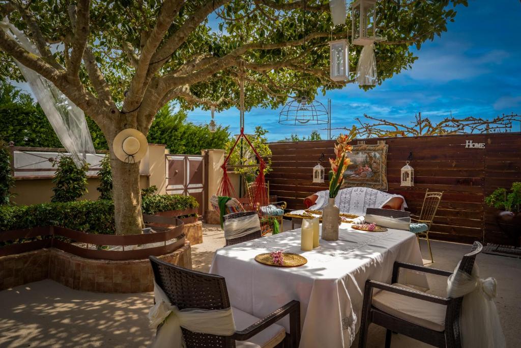 uma mesa com pratos de comida num pátio com uma árvore em Venetian Hill House em Áyios Dhimítrios