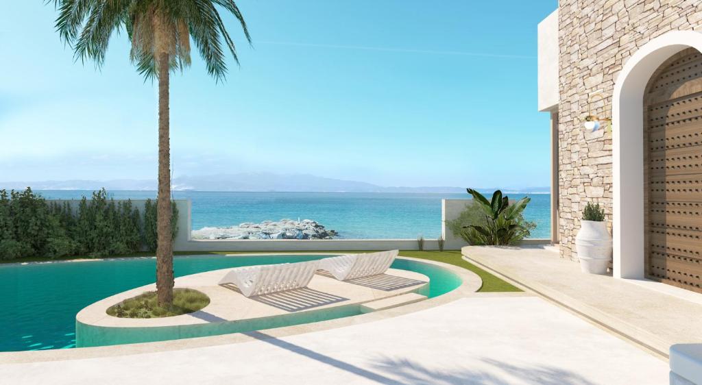 een villa met een zwembad en een palmboom bij Byblos Aqua-The Sea Front Luxury Villa in Skala Sotiros