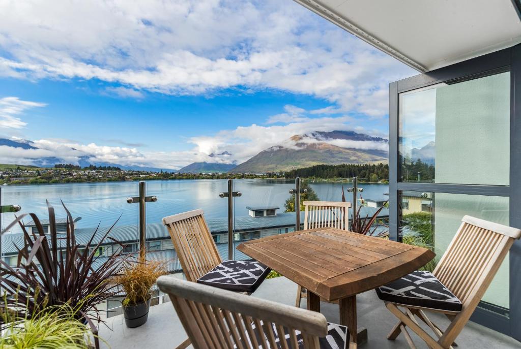 a patio with a table and chairs and a view of the water at Exciting Queenstown in Queenstown